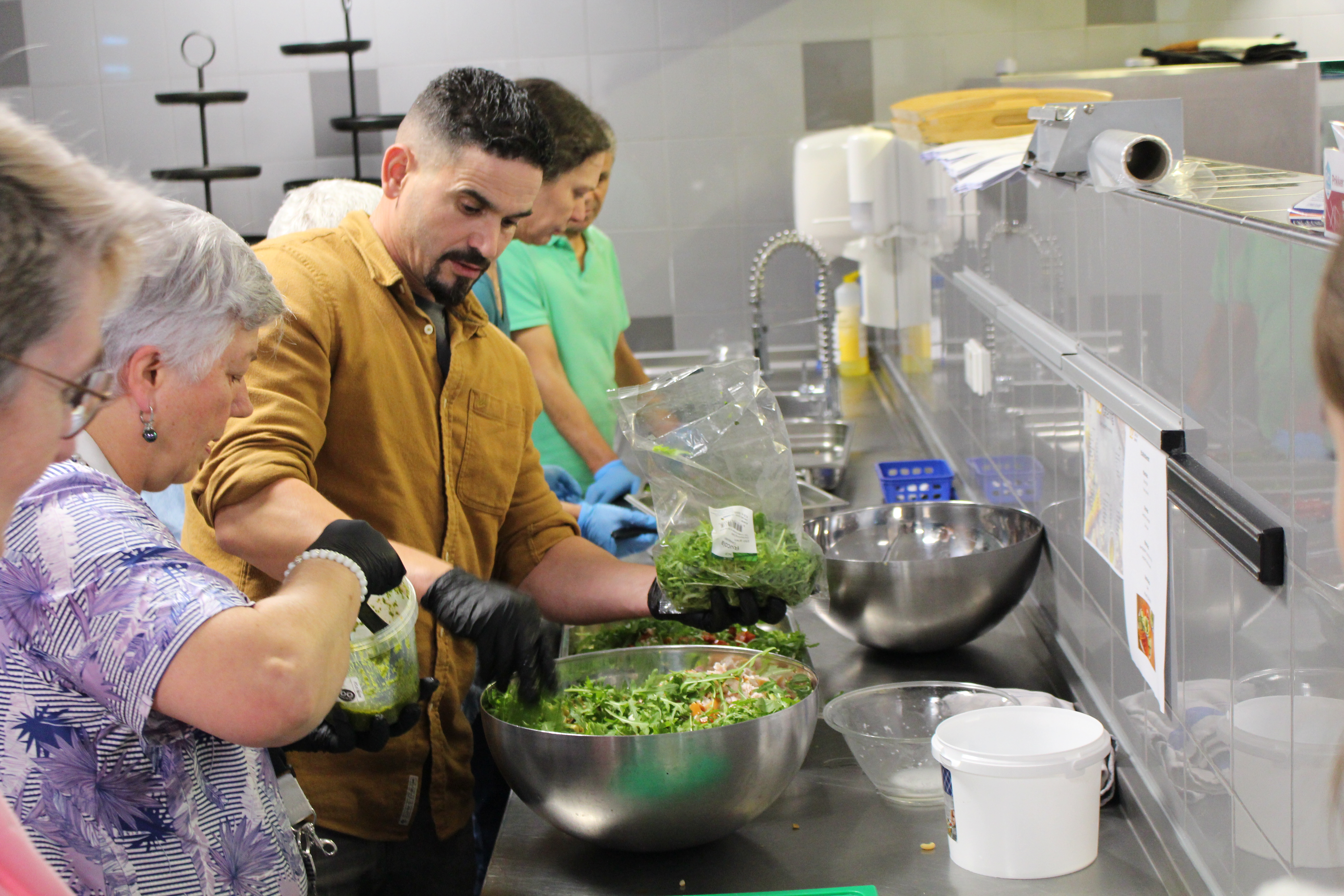 Collega's die en salade maken in de keuken