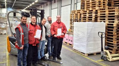 Vijf medewerkers van het magazijn bij een heftruck