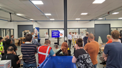 Een overzichtsfoto van een afdeling waarbij de medewerkers op hun rug te zien zijn