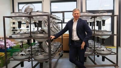 Frank Beker voor rekken met kappen van lantaarnpalen