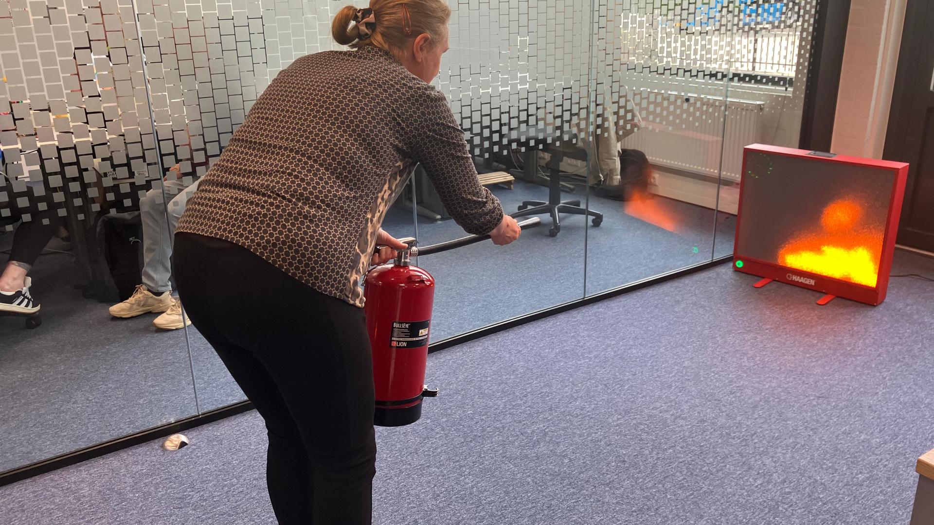 Oefenen met het blussen van een brandje tijdens de week van de veiligheid