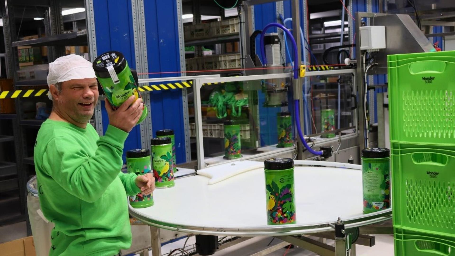 John aan het werk met het vullen van de koffieblikken