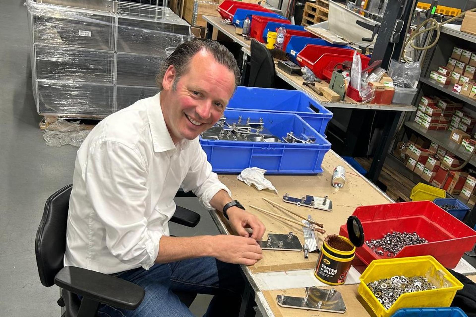 Sjoerd van het Erve aan een tafel met materiaal voor assemblage