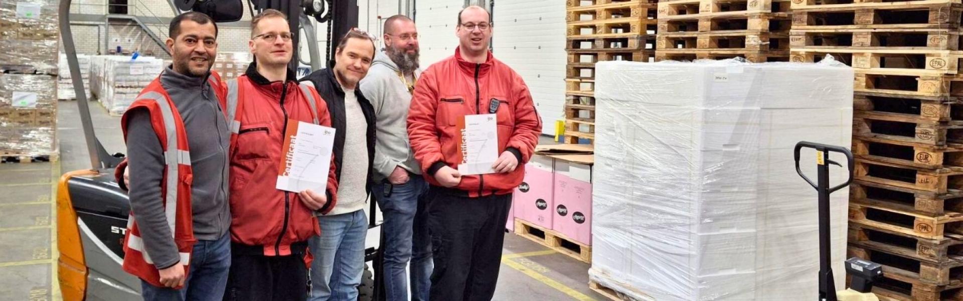 Vijf medewerkers van het magazijn bij een heftruck