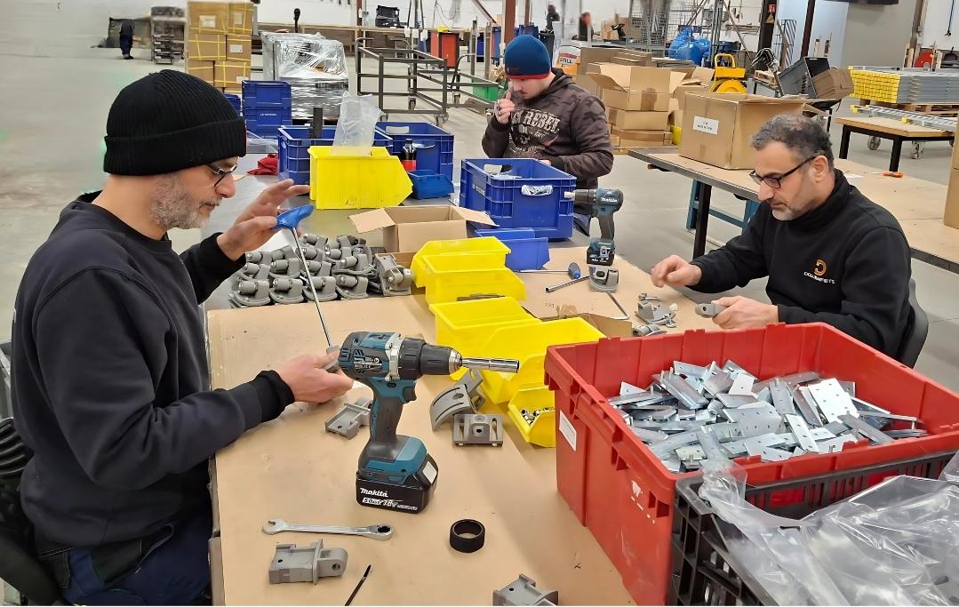 3 medewerkers zetten knikarmen van Donk in elkaar