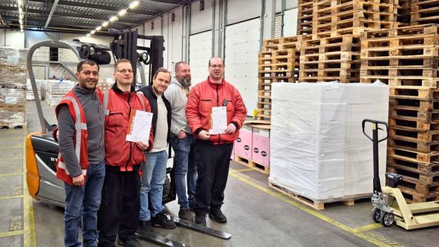 Vijf medewerkers van het magazijn bij een heftruck