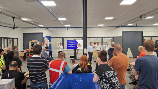 Een overzichtsfoto van een afdeling waarbij de medewerkers op hun rug te zien zijn